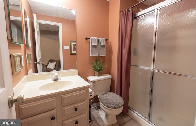 full bathroom featuring a stall shower, toilet, vanity, and tile patterned floors