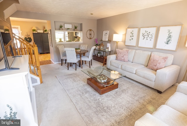 living room featuring carpet and stairway