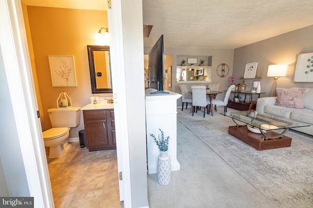 bathroom with vanity, toilet, and a textured ceiling