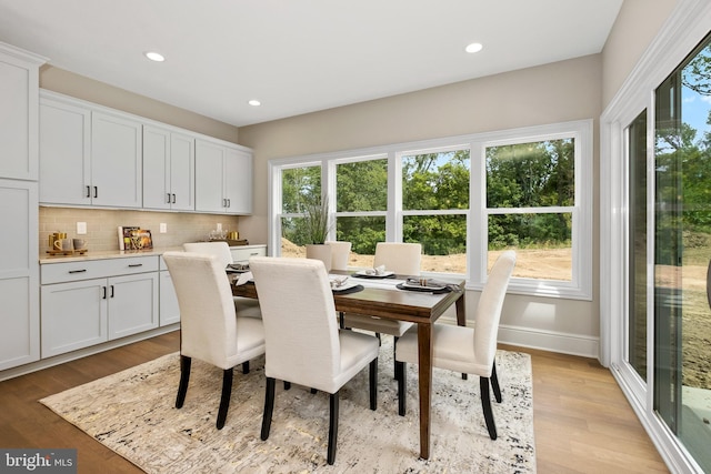 dining space with plenty of natural light, light wood finished floors, baseboards, and recessed lighting