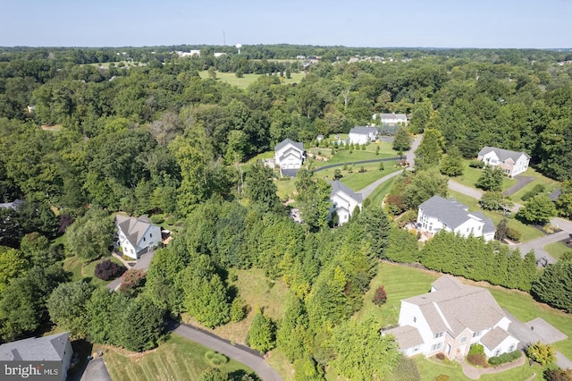 view of property location featuring a heavily wooded area and nearby suburban area