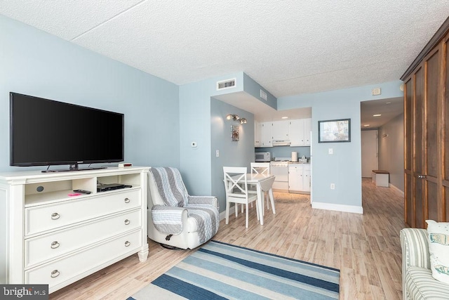 10900 Coastal Hwy Unit 805, Ocean City, MD 21842 - living area featuring light wood finished floors, a textured ceiling, and baseboards