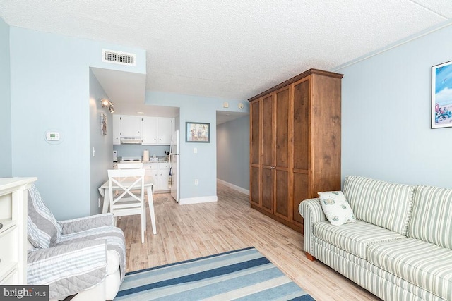 10900 Coastal Hwy Unit 805, Ocean City, MD 21842 - living area with light wood finished floors, a textured ceiling, and baseboards