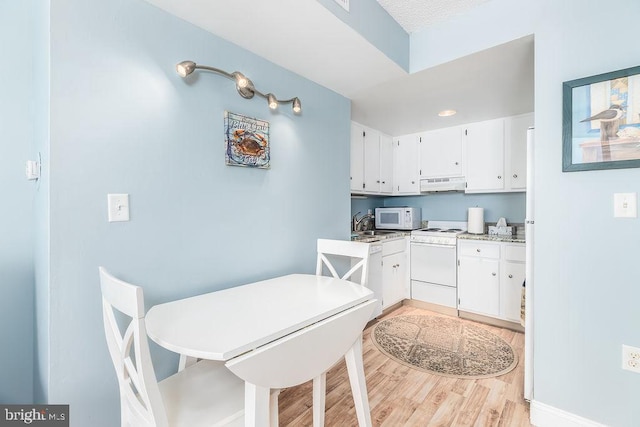 10900 Coastal Hwy Unit 805, Ocean City, MD 21842 - kitchen with under cabinet range hood, white appliances, light wood-style floors, and white cabinetry