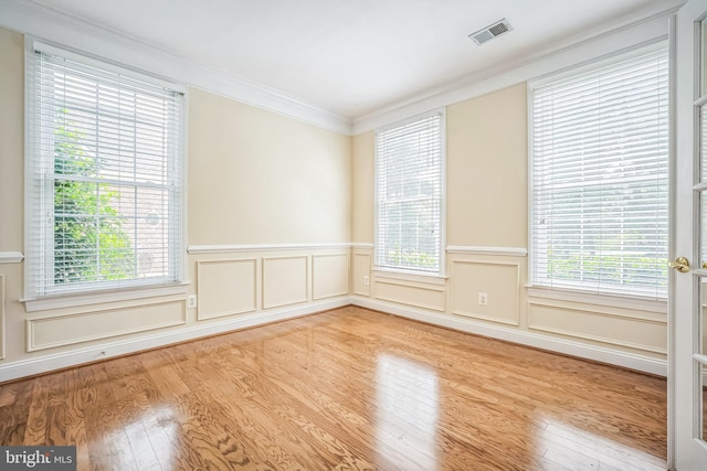 43692 Bermuda Dunes Ter, Leesburg, VA 20176 - empty room with wood finished floors, crown molding, a wainscoted wall, and a decorative wall
