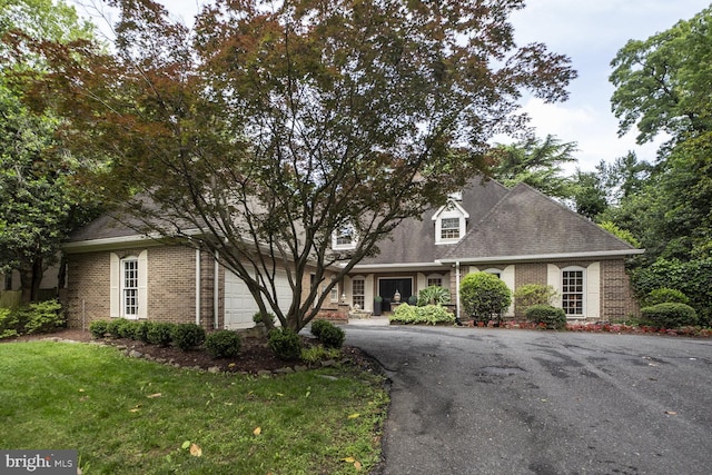 10013 Ormond Rd, Potomac, MD 20854 - cape cod-style house with brick siding, asphalt driveway, roof with shingles, and a front yard