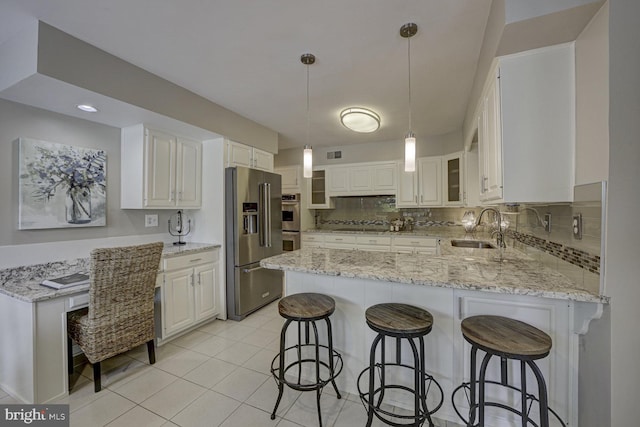 10013 Ormond Rd, Potomac, MD 20854 - kitchen featuring appliances with stainless steel finishes, a sink, a peninsula, and light stone counters