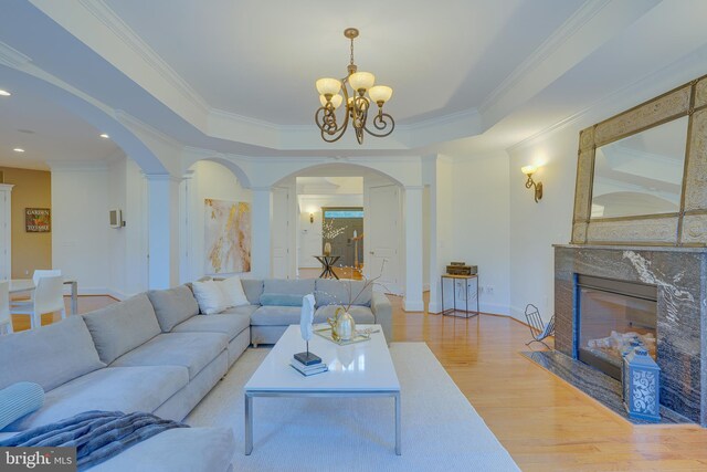 829 Golden Arrow St, Great Falls, VA 22066 - living room with arched walkways, ornamental molding, wood finished floors, a chandelier, and a premium fireplace