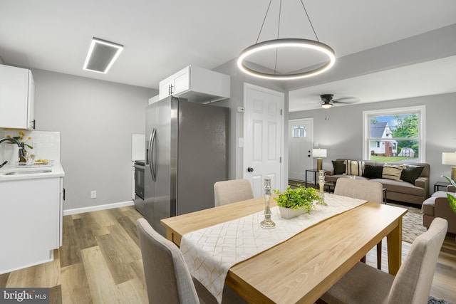 3531 Milford Mill Rd, Baltimore, MD 21244 - dining room featuring light wood finished floors, a ceiling fan, and baseboards