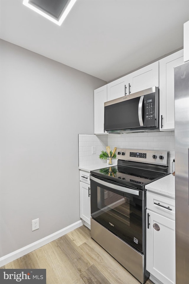 3531 Milford Mill Rd, Baltimore, MD 21244 - kitchen featuring stainless steel appliances, light wood-style floors, light countertops, and white cabinetry
