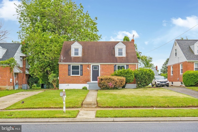 3531 Milford Mill Rd, Baltimore, MD 21244 - cape cod-style house featuring brick siding, a front lawn, central air condition unit, and a chimney