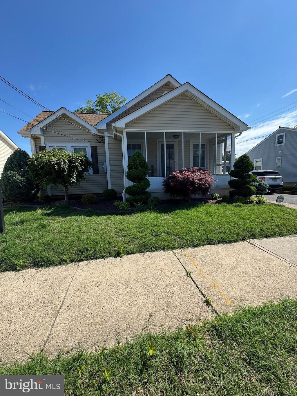 view of front of house with a sunroom and a front yard