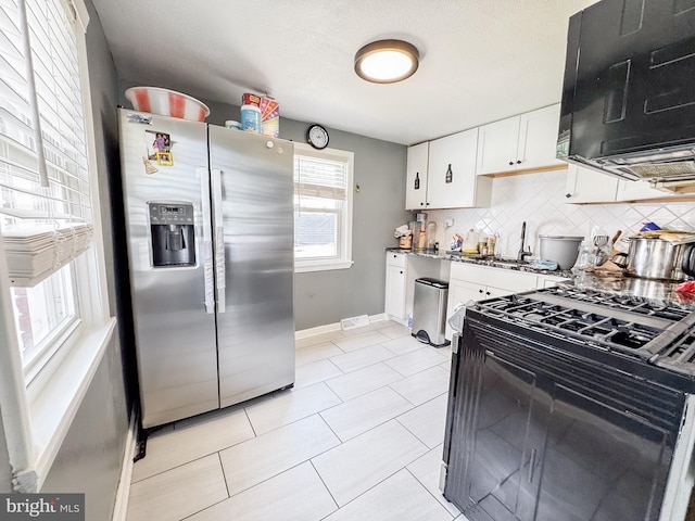 106 Killoran Dr, New Castle, DE 19720 - kitchen featuring stainless steel refrigerator with ice dispenser, black gas stove, white cabinets, backsplash, and baseboards