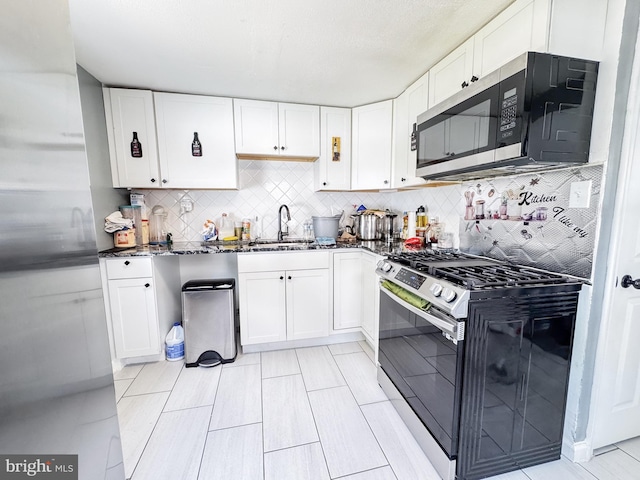 106 Killoran Dr, New Castle, DE 19720 - kitchen featuring stainless steel appliances, a sink, white cabinetry, dark stone counters, and tasteful backsplash