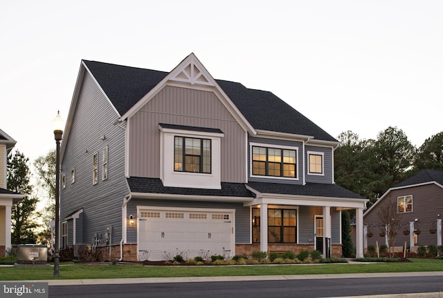 view of front of property with covered porch, a front yard, a garage, board and batten siding, and brick siding