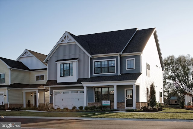 multi unit property featuring stone siding, an attached garage, a front yard, roof with shingles, and board and batten siding