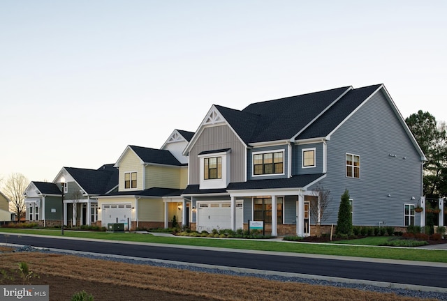 view of front of house featuring a porch, a garage, and a front yard