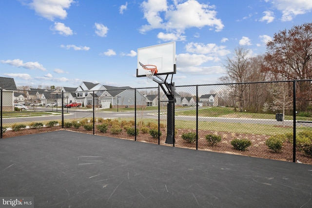 view of sport court featuring a residential view, fence, and community basketball court