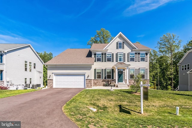 colonial house featuring driveway, an attached garage, a front lawn, stone siding, and cooling unit