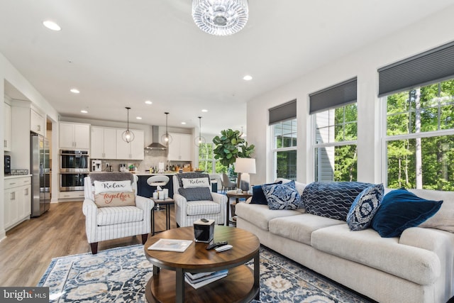 living room featuring healthy amount of natural light, recessed lighting, and light wood finished floors