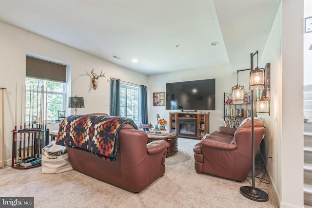 living area featuring carpet floors, recessed lighting, and a glass covered fireplace
