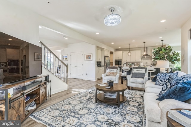 living area with light wood-type flooring, stairs, and recessed lighting