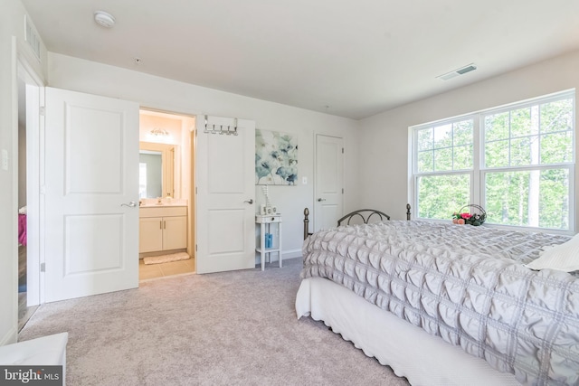bedroom with carpet flooring, ensuite bath, and baseboards