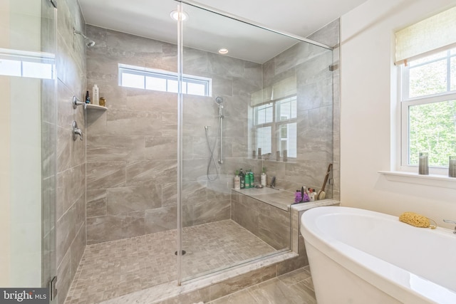 bathroom with a stall shower, healthy amount of natural light, and a garden tub