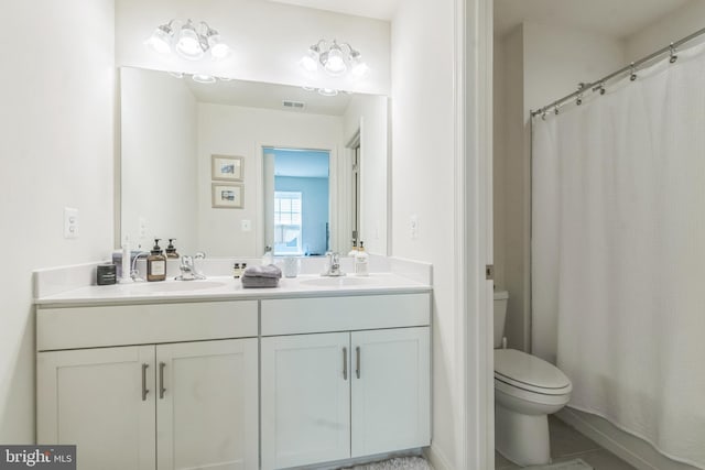 bathroom featuring toilet, double vanity, and a shower with shower curtain
