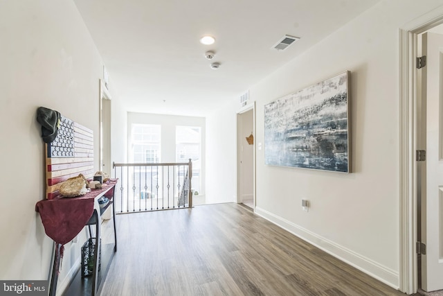 corridor with wood finished floors and baseboards