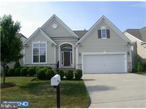 traditional home featuring concrete driveway, a front lawn, and a garage