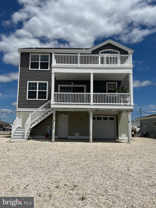 43 W Susquehanna Dr, Little Egg Harbor Twp, NJ 08087 - coastal home featuring an attached garage, stairs, gravel driveway, and a balcony