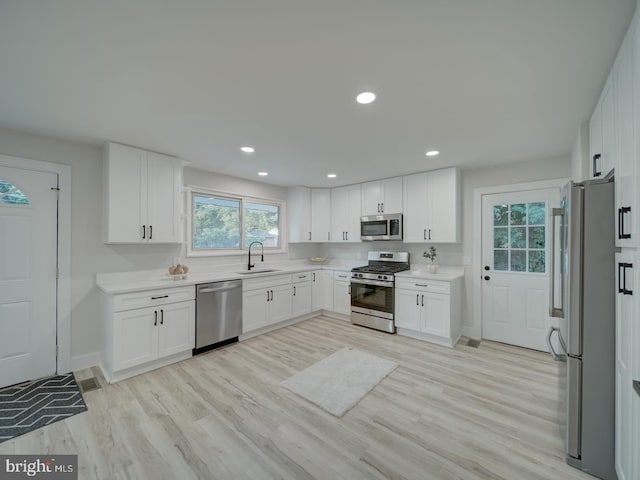3207 28th Pkwy, Temple Hills, MD 20748 - kitchen featuring appliances with stainless steel finishes, light wood-style floors, light countertops, white cabinets, and recessed lighting