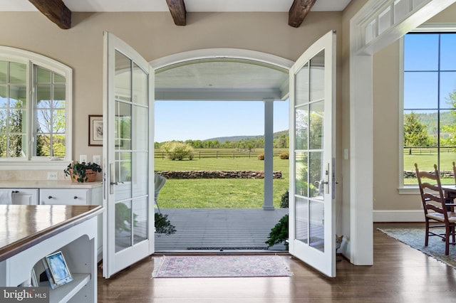 entryway featuring beam ceiling, french doors, dark wood-type flooring, baseboards, and a rural view