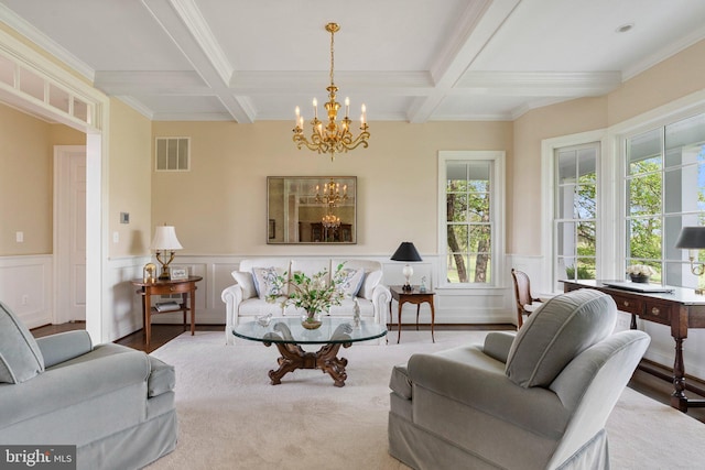 living area featuring a chandelier, coffered ceiling, beamed ceiling, a wainscoted wall, and ornamental molding