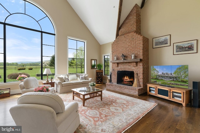 living room featuring high vaulted ceiling, dark wood-style flooring, and a brick fireplace