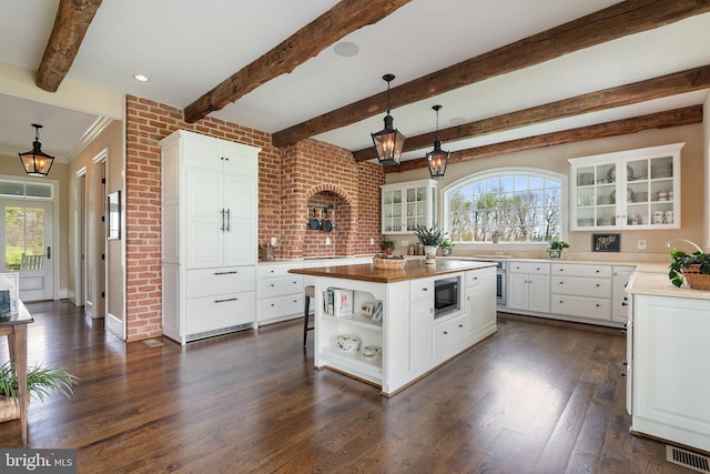 kitchen featuring built in microwave, dark wood finished floors, glass insert cabinets, open shelves, and beam ceiling
