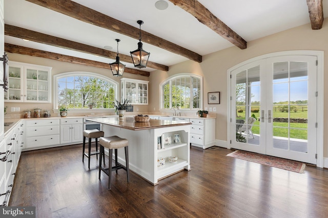 kitchen featuring open shelves, french doors, dark wood-type flooring, a kitchen island, and white cabinets