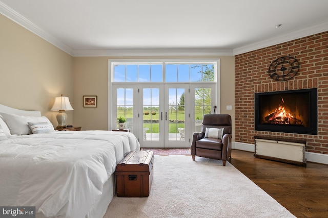 bedroom with a fireplace, access to exterior, crown molding, wood finished floors, and french doors