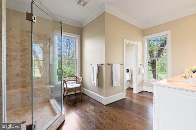 full bathroom with a sink, wood finished floors, healthy amount of natural light, and crown molding