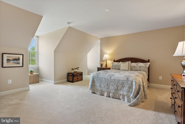 bedroom featuring light carpet, baseboards, and vaulted ceiling
