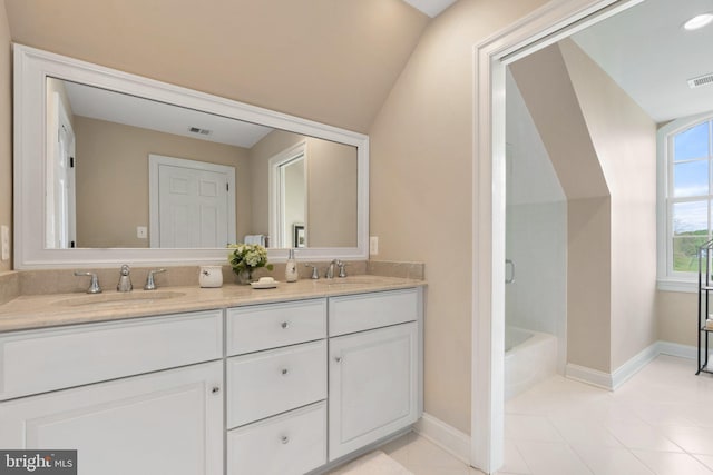 full bath with double vanity, baseboards, a tub, and tile patterned flooring