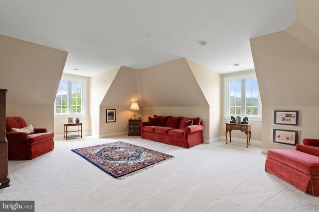carpeted living room with vaulted ceiling and baseboards