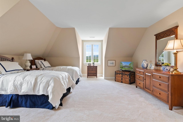 bedroom with light carpet, vaulted ceiling, and baseboards