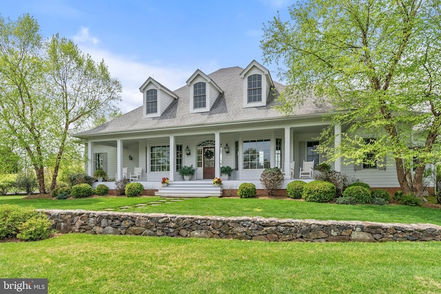 cape cod house with covered porch, a front lawn, and roof with shingles
