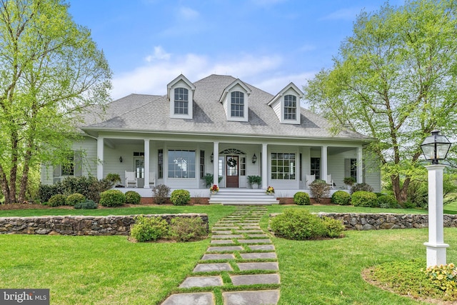 cape cod home featuring covered porch, a front yard, and roof with shingles