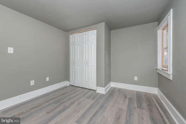 1412 W Baltimore St, Baltimore, MD 21223 - unfurnished bedroom featuring wood finished floors, baseboards, and a closet