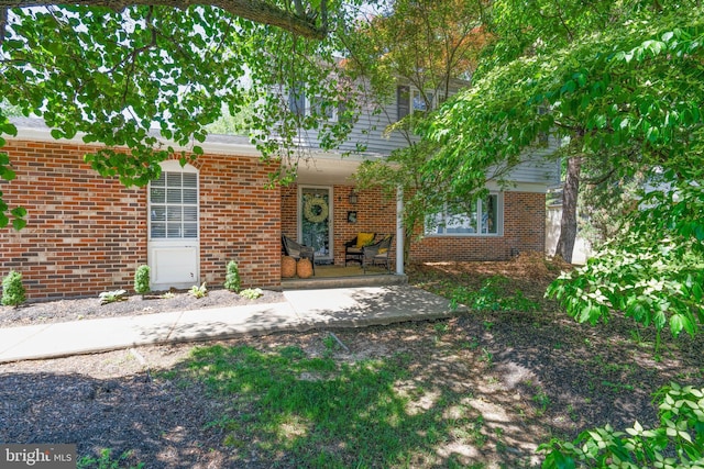 view of front of house with brick siding and covered porch
