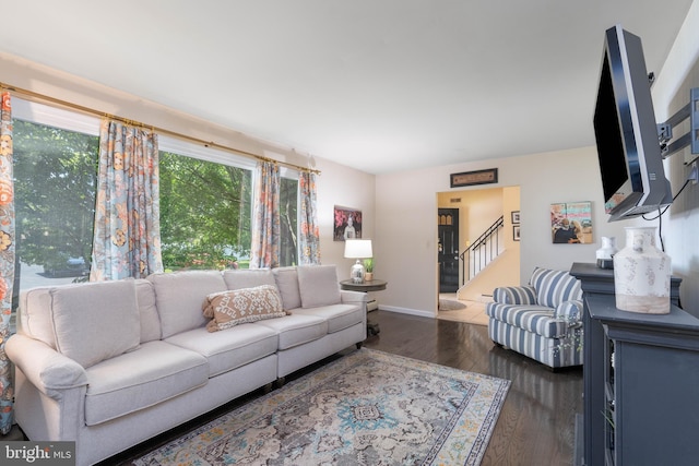 living room featuring wood finished floors, stairs, and baseboards