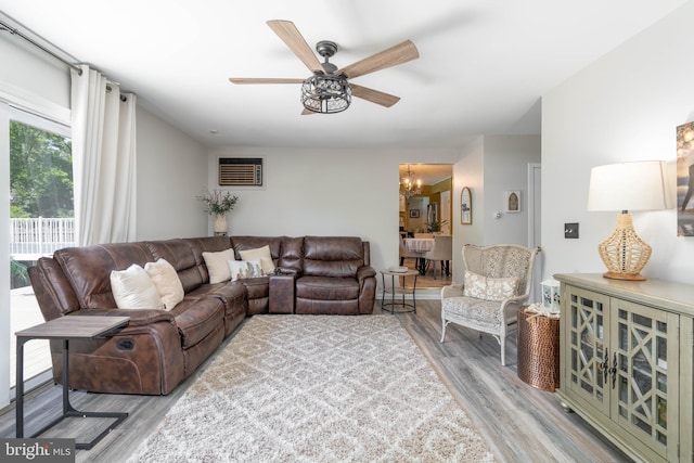 living area featuring a ceiling fan, wood finished floors, and a chandelier